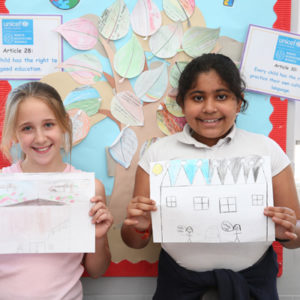 Children at a Rights Respecting School hold up their drawings